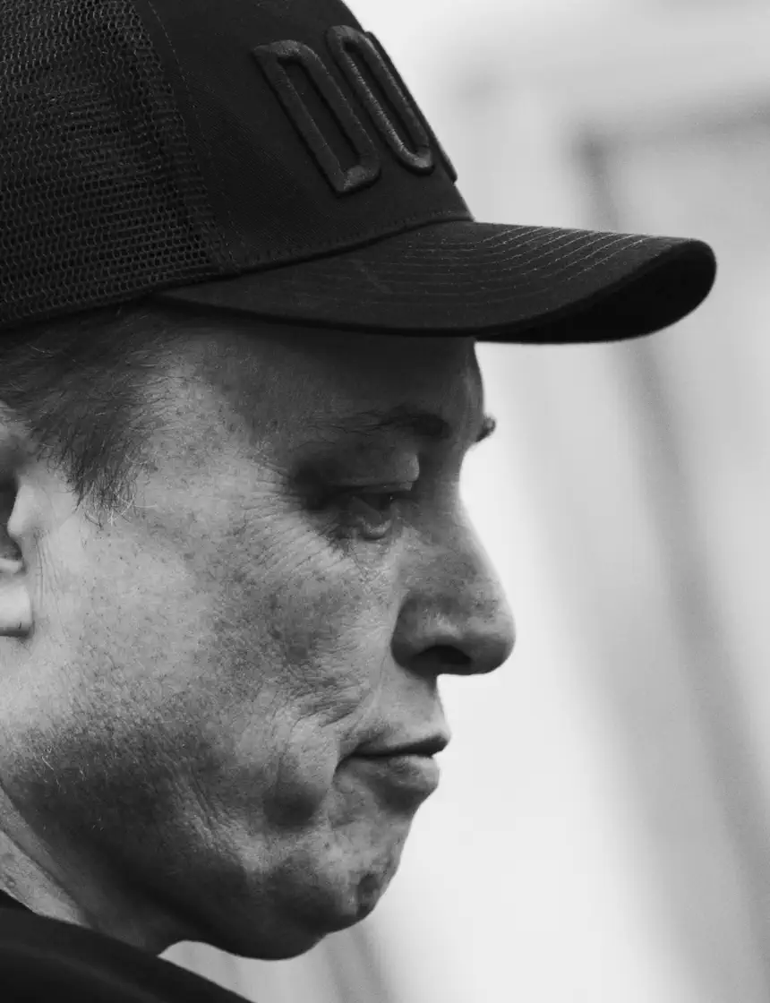 A billionaire wearing a black baseball cap